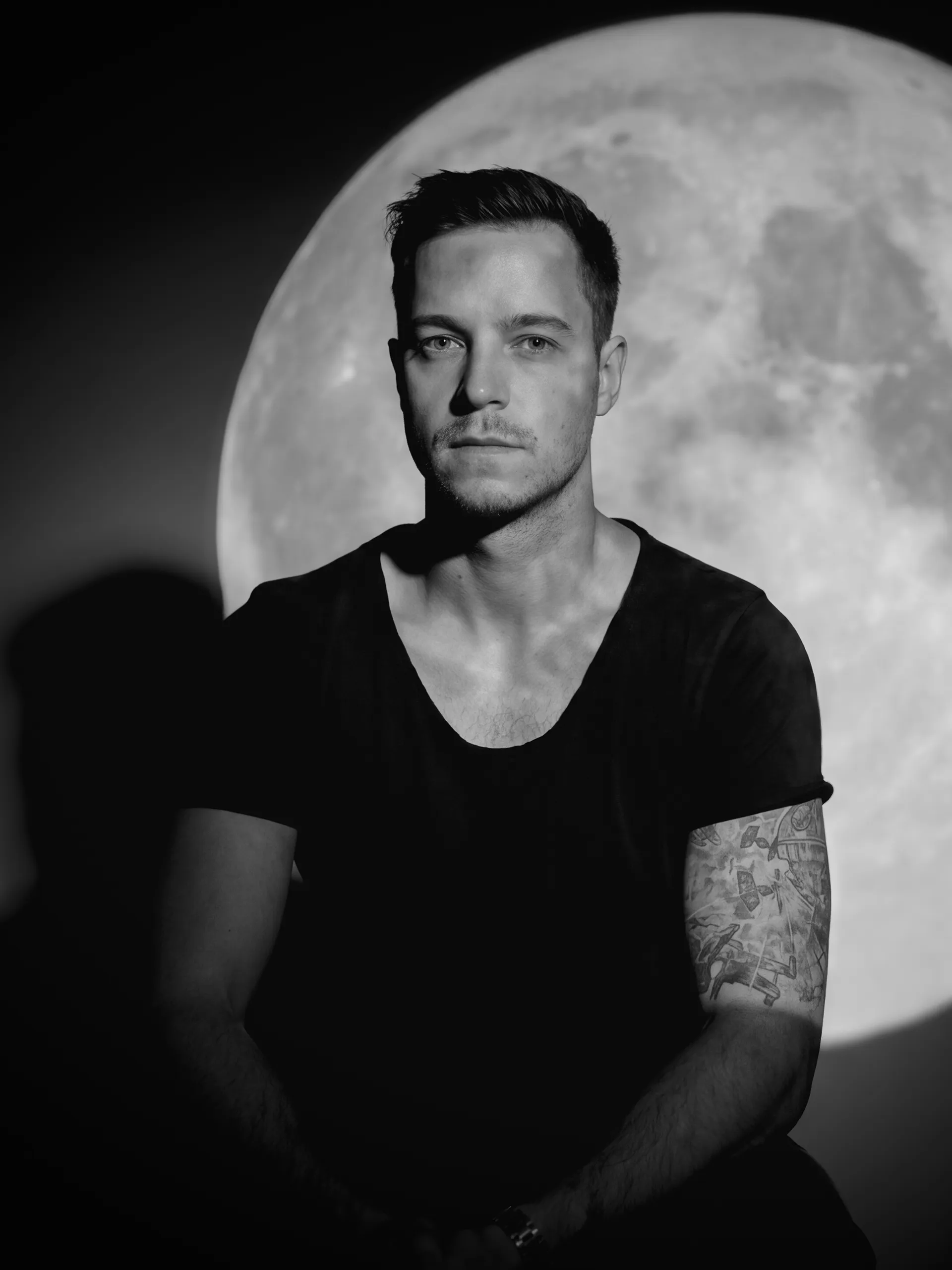 Travis Campbell portrait, lit against a full moon backdrop